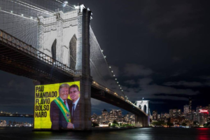 Protesto em Nova York projeta Flávio Bolsonaro entregando faixa presidencial a Trump